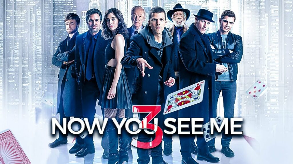 Affiche promotionnelle du film Now You See Me 3, montrant les huit personnages principaux alignés en tenue sombre, avec des cartes à jouer en lévitation, et le titre en bas de l’image.