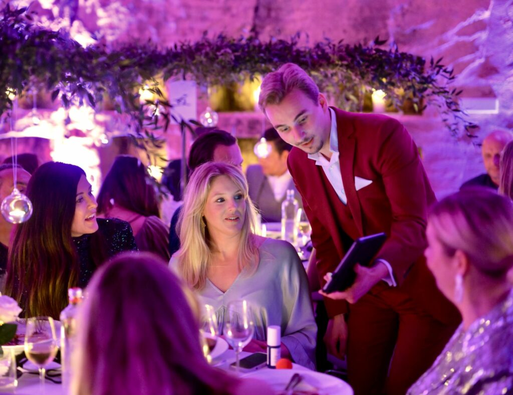 Maxime Mandrake en close-up digital à la table d'invités lors d'une soirée privée : la magie au service des événements de luxe